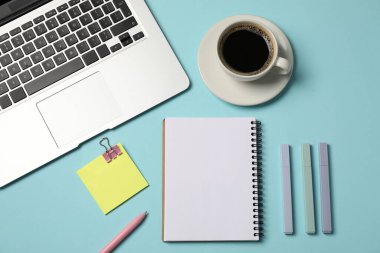 Not defteri, diğer kırtasiye malzemeleri, açık mavi zemin üzerinde kahve ve laptop, düz uzanma