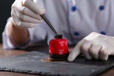 Şekerci lezzetli bir tatlı hazırlıyor. Masada çikolata traşı, yakın plan.