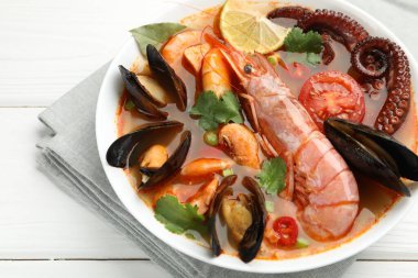 Lezzetli deniz ürünleri çorbası beyaz ahşap masada, yakın plan.