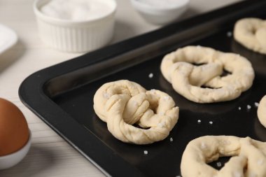 Beyaz ahşap masada çiğ kraker tepsisi, yakın plan.