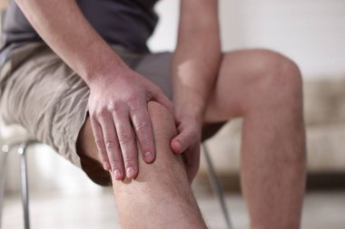 Evinde diz ağrısı çeken bir adam, yakın plan.