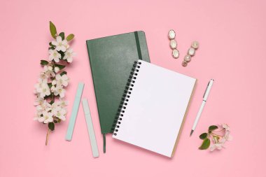 Pembe zemin üzerinde planlayıcı ve kırtasiye malzemesi, düz uzanma