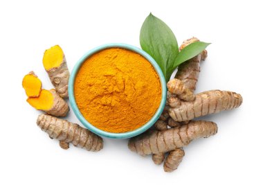 Tabaktaki zerdeçal tozu, kökler ve yeşil yapraklar beyaza izole edilmiş, üst manzara