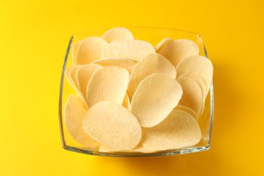 Sarı arka planda lezzetli patates cipsi, yakın plan.