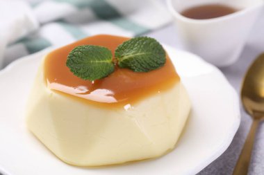 Karamel soslu lezzetli puding ve nane şekeri, yakın plan.