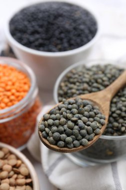 Beyaz masada farklı türde mercimek, yakın plan.