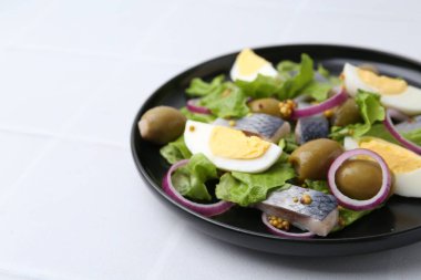 Ringa balıklı lezzetli salata, yumurta, hardal ve sebzeler beyaz fayanslı masada, yakın plan. Metin için boşluk