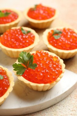 Kırmızı havyarlı tart ve bej masadaki maydanoz, yakın plan.