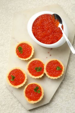 Kırmızı havyarlı turta ve bej arka planda maydanoz.