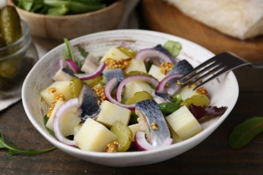 Ringa balıklı lezzetli salata, sebzeler ve hardal ahşap masada, yakın plan.