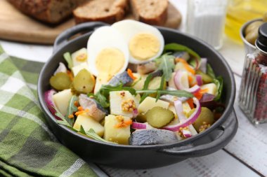 Ringa balıklı lezzetli salata, yumurta ve sebzeler beyaz ahşap masada servis edilir, yakın plan.