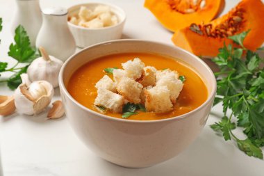 Lezzetli balkabağı kremalı çorba, kızarmış ekmek ve mayonezli beyaz masa, yakın plan.