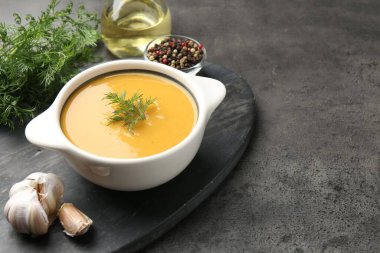 Gri masada servis edilen dereotlu mercimek kremalı lezzetli çorba, yakın plan. Metin için boşluk