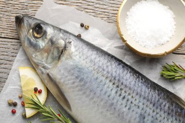 Tuzlu ringa balığı ve baharatlar ahşap masada, düz yatıyordu.