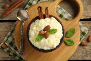 Tahta masada servis edilen bademli, nane ve tarçınlı lezzetli sütlaç.