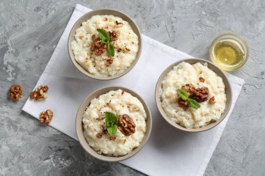 Cevizli, nane ve ballı lezzetli sütlaç gri masada, düz yerde.