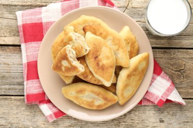 Lezzetli kızarmış pirinçli börek (dolma turtalar) ve ahşap masa üzerinde süt, üst manzara