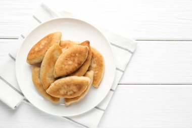 Beyaz ahşap masa üzerinde nefis kızarmış pirizky (doldurulmuş turtalar), üst manzara. Metin için boşluk