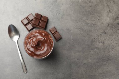 Lezzetli puding ve gri masada bir parça çikolata. Metin için boşluk