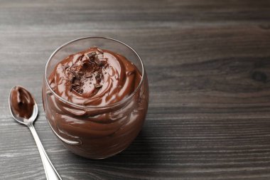 Bardakta çikolatalı puding ve tahta masada kaşık, yakın plan. Metin için boşluk