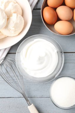 Lezzetli ev yapımı kurabiyeler, malzemeler ve çırpılmış çırpılmış gri ahşap masa, düz uzanmış.