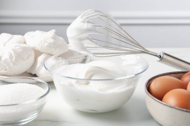 Krem şantili çırpma çırpma ve diğer malzemeler ışık masasında, yakın plan. Kurabiye pişiriyorum.