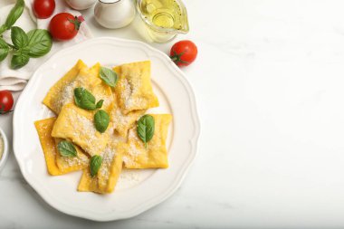 Beyaz mermer masada servis edilen peynirli ve fesleğenli lezzetli ravioli. Metin için boşluk