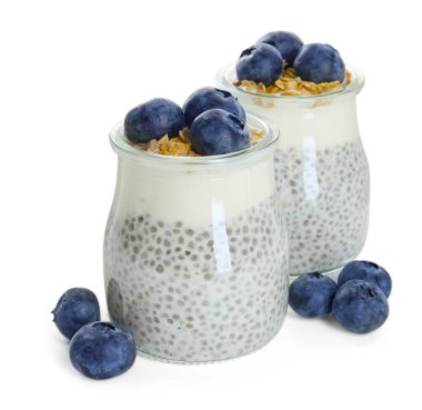 Chia tohumlu lezzetli puding, yoğurt, yaban mersini ve granola beyaza izole edilmiş bardaklarda. Süper yemek.