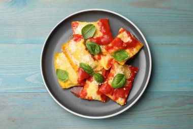 Domates soslu lezzetli ravioli, parmesan peyniri ve fesleğen mavi ahşap masa, üst manzara.