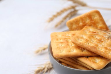 Beyaz masadaki buğday dikenli tuzlu krakerler, yakın plan. Metin için boşluk