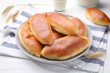 Lezzetli fırında köfteler ve çiviler beyaz ahşap masada, yakın plan.