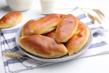 Lezzetli fırında köfteler ve çiviler beyaz ahşap masada, yakın plan.