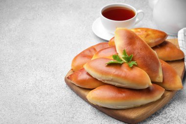 Lezzetli fırında köfteler ve bir fincan çay gri desenli masada, yakın plan. Metin için boşluk