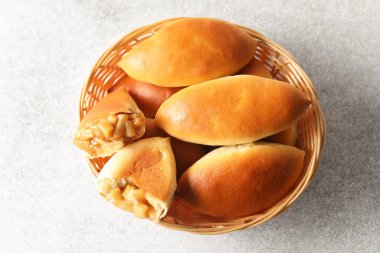 Hasır sepetin içinde leziz pişmiş köfteler açık gri masada, üst tarafta.