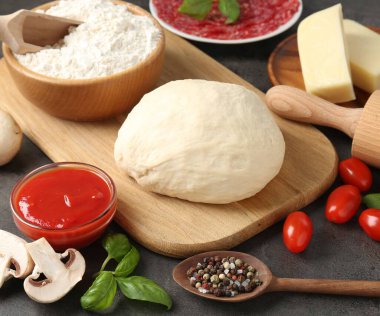 Pizza yapıyorum. Gri desenli masadaki farklı malzemeler, yakın plan.
