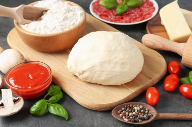 Pizza yapıyorum. Gri desenli masadaki farklı malzemeler, yakın plan.