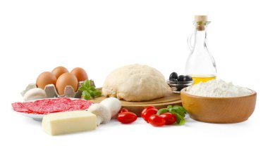 Pizza yapıyorum. Farklı malzemeler beyaza izole edilmiş.