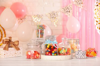 Çikolata. Bir sürü farklı tatlı ve hediye kutuları beyaz ahşap masa üzerinde, şenlikli bir odada.