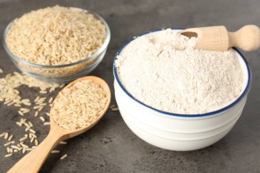 Kahverengi pirinç ve un gri masada, yakın plan.