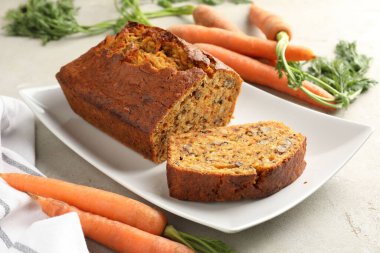 Açık gri masada fındıklı ve sebzeli ev yapımı havuçlu kek, yakın plan.