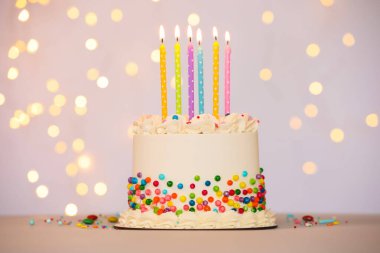 Renkli serpiştirilmiş lezzetli bento keki ve yanan mumlar arka planda, bokeh etkisi