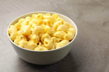 Gri masada peynir soslu leziz makarna, yakın plan. Metin için boşluk