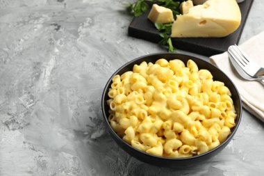 Gri masada servis edilen peynir soslu lezzetli makarna, yakın plan. Metin için boşluk