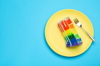 Açık mavi masa üzerinde nefis bir gökkuşağı pastası, üst manzara. Metin için boşluk