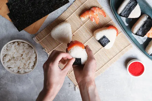 Onigiri yapan kadın (Japon pirinç topları) ışık masasında, üst manzara