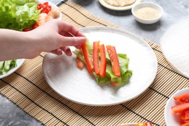 Açık gri masada nefis börek yapan bir kadın, yakın plan.