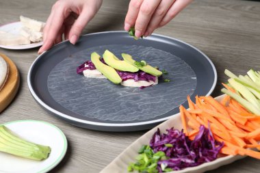 Gri ahşap masada nefis börek yapan kadın, yakın plan.