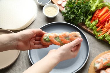 Gri ahşap masada nefis börek yapan kadın, yakın plan.