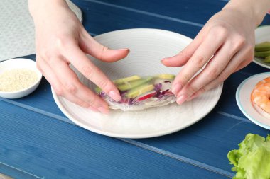 Mavi ahşap masada nefis börek yapan bir kadın, yakın plan.