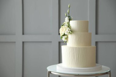 İçerideki masada çiçek desenli nefis düğün pastası, mesaj için yer var.